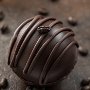 摩卡咖啡炸弹在粗糙的表面与咖啡豆。热可可炸弹，热巧克力炸弹，如何制作热巧克力炸弹，最佳巧克力炸弹口味，好市多巧克力炸弹，热巧克力炸弹所有食谱，如何储存巧克力炸弹，热储存热可可炸弹，如何储存摩卡咖啡炸弹，我是面包师，iambaker