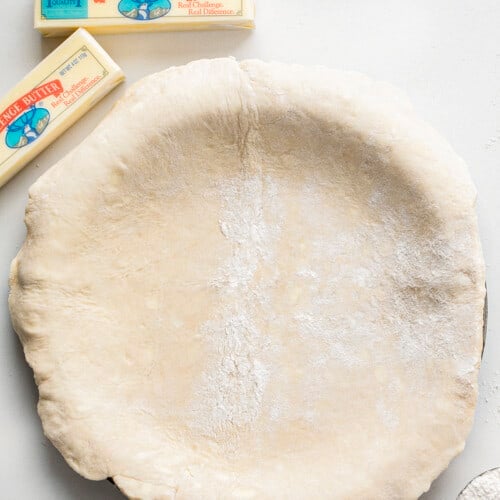 奶油派皮面团放在一个馅饼盘黄油。