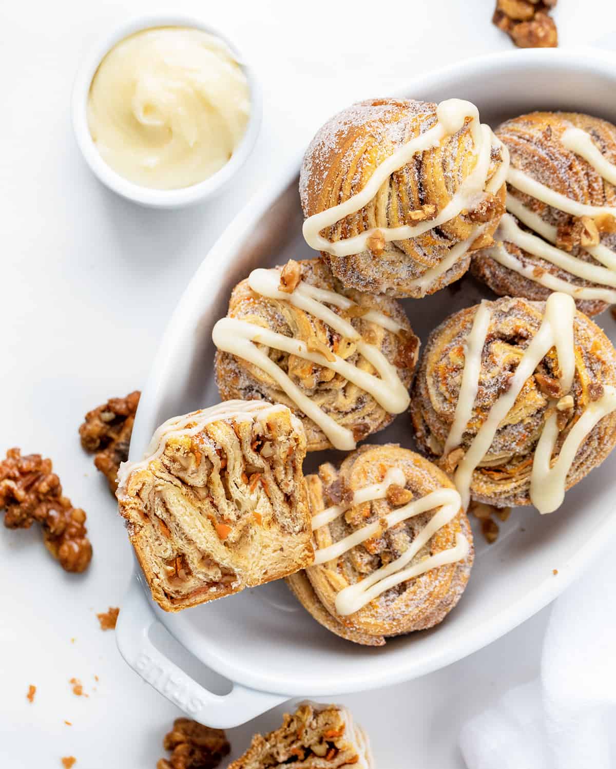 White Oval Dish Filled with Carrot Cake Cruffins and One Cut in Half.
