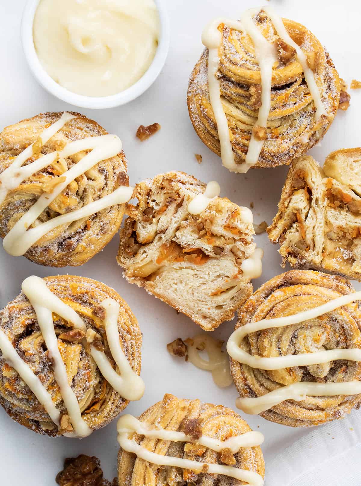 CLose up of Carrot Cake Cruffins on a White Counter with a Cream Cheese Drizzle.