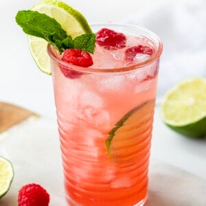 一杯覆盆子石灰莫吉托在一个迷你大理石砧板和酸橙树莓。