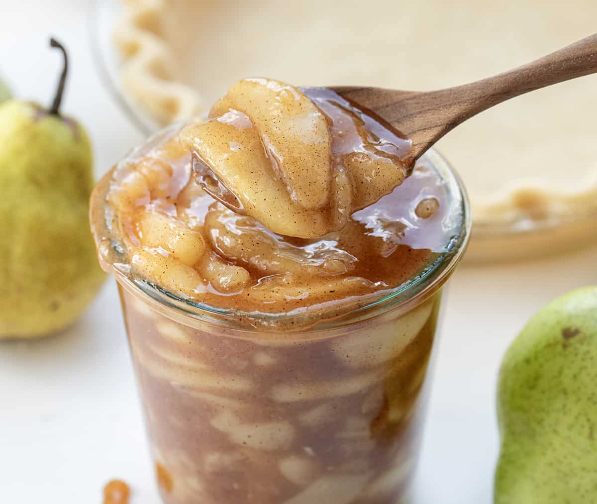 勺子在罐梨馅派皮在背景。