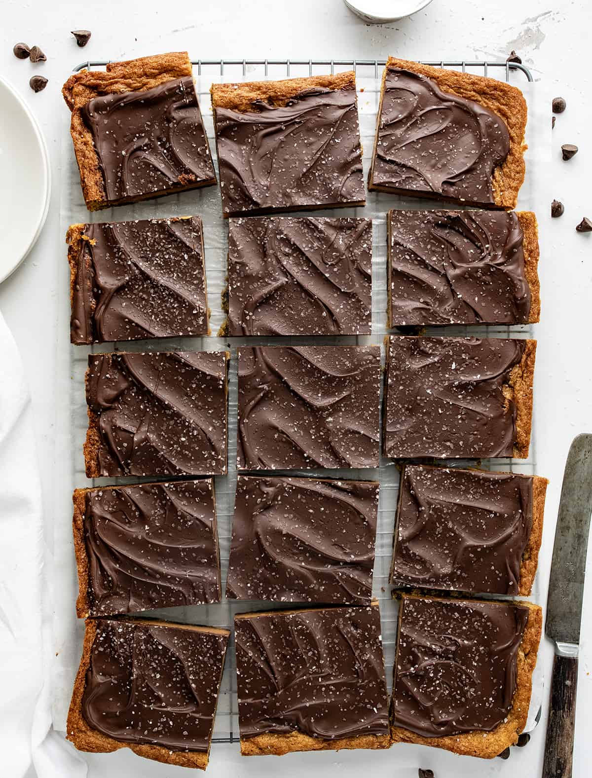 咸焦糖饼干酒吧柜台上一个白色的盘子和一把刀切成块。